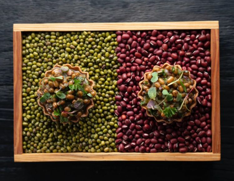 Tartina di segale e fagioli marinati con profumi dell'orto. Servita su un letto di coloratissimi frijoles tipici della regione andina