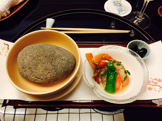 Ishiyaki rovente: il sasso a sinistra è stato scaldato su fiamma per un'ora. Nel piattino a destra, chele di granchio e scampi marinati con base sakè e acqua di mare. Per cuocerli, è sufficiente poggiarli per qualche secondo sulla pietra
