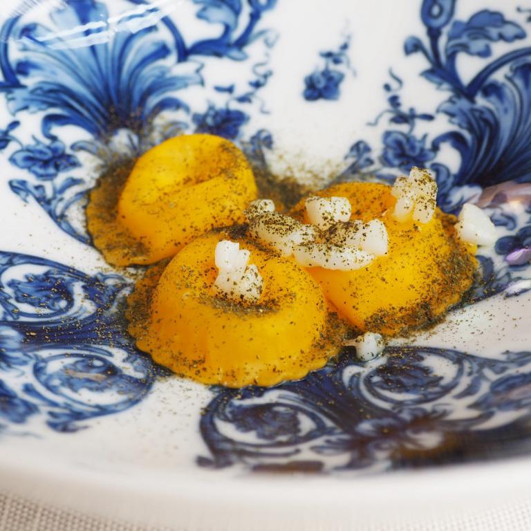 Pasta in bianco al contrario: ravioli ripieni di olio evo e parmigiano conditi con polvere di cavolo nero essiccato e seppioline saltate in padella
