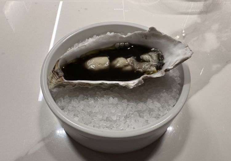 Ostrica in brodo di caviale: l’ostrica è cotta poche e servita con una salsa a base di pesce alla base, limone salato, limone arso, scalogni marinati e brodo di caviale, dal colore nero intenso e che subito cattura lo sguardo. Anche qui, aromaticità ed equilibrio di sapori ben centrati
