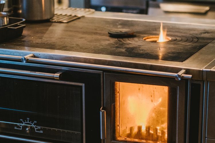 I cuochi di Orti lavorano con il fuoco vivo di una termocucina a legna, alimentata dalle potature degli alberi della tenuta: un esempio concreto di energia circolare e rispetto per l’ambiente
