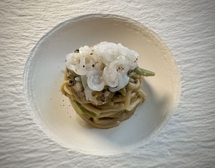 Yaki Udon (spaghetto di grano duro e tenero, poco calloso, con un mordente soffice) mantecato con crema di calamaro cotto in brodo dashi, verdure croccanti. Viene terminato con del calamaro crudo sopra, black lime ed emulsione di riccio di mare sardo sul fondo (che si potrebbe sentire di più, regalando più equilibrio alla portata)
