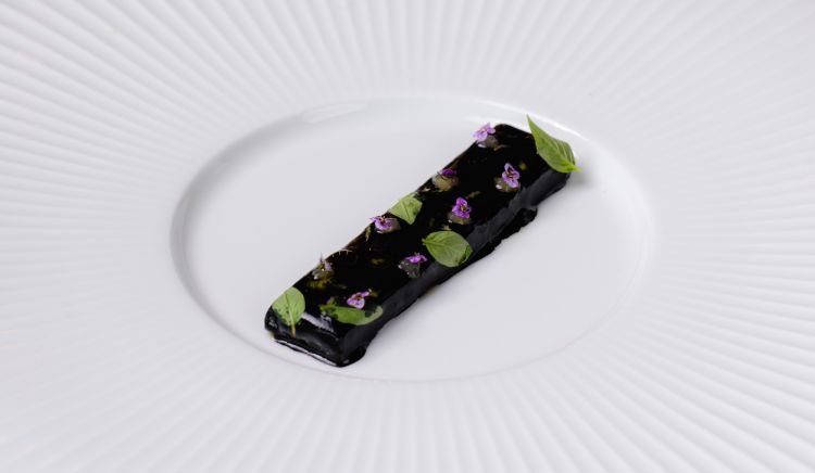 Calamaro
Calamaro cotto a bassa temperatura, Thai green curry, crema al tamarindo e limone fermentato. È uno dei passaggi più identitari del percorso: la contaminazione asiatica non appare come un semplice esercizio stilistico, ma diventa uno strumento per valorizzare il prodotto e giocare sull’equilibrio tra spezie, acidità e dolcezza
