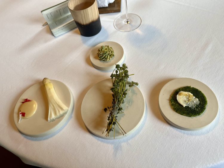 The initial composition of Mugaritz's 2023 menu, entitled Recuerdos del futuro: in the centre, there is a bouquet of glazed thyme; above, the millefeuille of happiness
