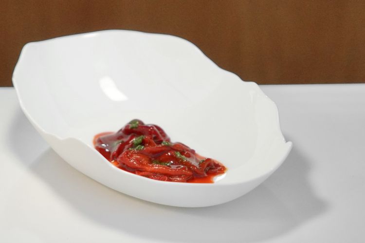 Arriva il pane, opera del pasticcere e lievitista Gianluca Colucci: una pagnotta con lievito madre e grani integrali siciliani, un cracker composto esclusivamente da semi di lino rosso e zucca e un grissino preparato con una farina di Russello proveniente da Lipari e, in questa versione, con cipolla locale. Il cosiddetto burro, dal colore leggermente grigio, è in realtà un’emulsione di semi di girasole tostati, acqua e miele. Poi il piatto, Peperone: peperone essiccato arrosto, muhammara di peperone, glassa di peperone. Per eliminare la pelle senza cuocere immediatamente la polpa, il peperone viene investito da una fiamma particolarmente intensa, così una volta spellato, rimane ancora crudo. Viene quindi affumicato, cotto in acqua di peperone arrosto, disidratato e successivamente reidratato nello stesso liquido. È servito con una glassa di peperone arrostito, chimichurri e una preparazione ispirata alla muhammara libanese, con peperone, frutta secca e melassa di melograno