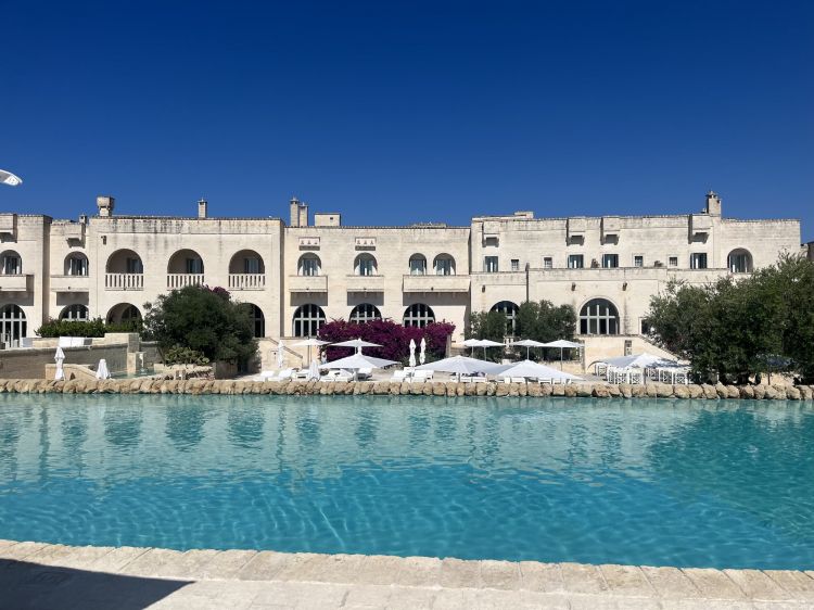 Una delle due piscine (su piani sfalsati) di fronte a il Porticato, il ristorante easy del Borgo cui attardarsi a pranzo. O all'aperitivo: nella carta dei cocktail dell'attiguo Bar del Portico spicca U'Frisc, un mocktail fresco con menta, limone femminiello, zenzero, soda e zucchero. I bar del Borgo sono 3: il Capanno, nella Corte, e l'Angoletto, alla piscina della Frasca, specialità gelato, puccia pugliese, succhi e smoothies
