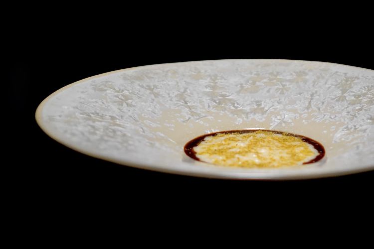 Riso, crespino, ginepro e camomilla. Il riso della Riserva San Massimo viene servito sopra una crema di crespino, piccola bacca rossa e fortemente acida coltivata nell&rsquo;orto del ristorante. La preparazione &egrave; completata da una salsa al ginepro e da polvere di camomilla. &Egrave; un riso serio, magari non il pi&ugrave; rappresentativo ma di grande soddisfazione palatale, quasi una pausa tra le tensioni delle altre portate
