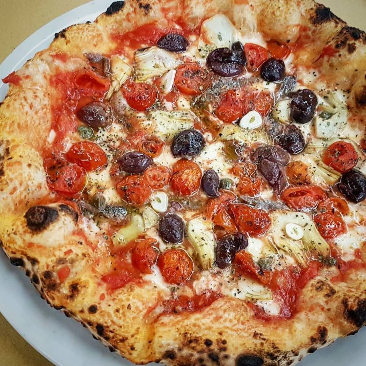 Pizza Marinara Più con pomodoro San Marzano, olive itrane, acciughe del cantabrico, foglie di carciofino, aglio, origano pugliese e olio extravergine