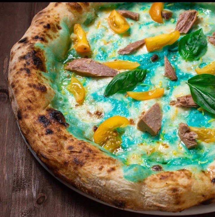 Azzurro di Cetara, con crema di blue curaçao con latte di mozzarella di bufala, fiordilatte, ventresca di tonno rosso Armatore, pomodorino datterino semi dried, datterino giallo, zest di limone, colatura di alici. Il menu Futurama si chiude con la Pizza a portafoglio dolce: ripiegata in 4 - così come è nata nei vicoli di Napoli - e poi farcita con confettura di pomodoro san marzano e crema cheese cake