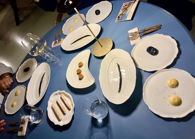 Meravigliosa la piccola pasticceria, assaggi mignon che giocano attorno alla tradizione dei dolciumi italiani. C’è un finto baccello di vaniglia - ricavato da un banana cotta in forno, farcita con crema di banane e vaniglia, laccata con succo di cottura delle bucce e ridotta con rhum bianco. Un raviolo freddo, tipico del Carnevale d’Abruzzo, disegnato da una pasta di strozzapreti, ripieno di crema pasticcera, sale e zucchero e cannella. Un cremino allo squacquerone caramellato ai fiori d’arancio, riedizione romagnola del dulce de leche. Una rotella di pasta alla liquirizia tipo Haribo – in realtà sono spaghettini scotti e poi cotti in sciroppo con nero di seppia e liquirizia. E un cannolo di grasso di maiale cotto a vapore