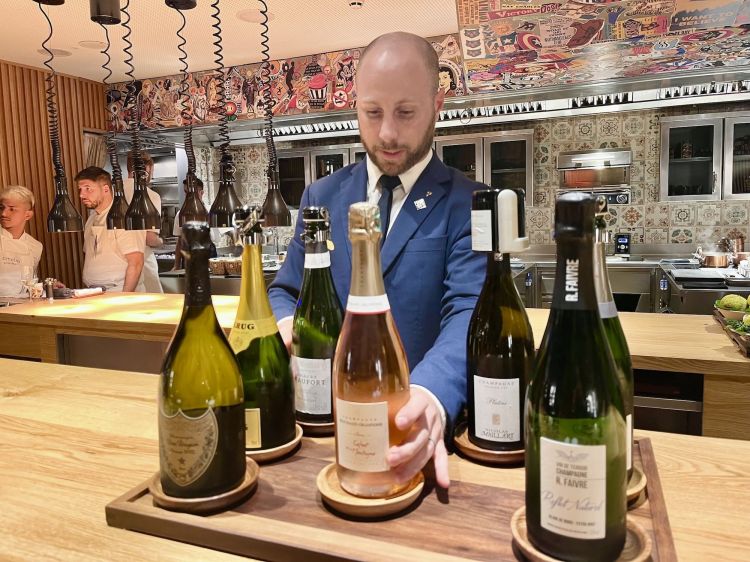 Il restaurant manager e sommelier Romain Mesplet poggia subito sul counter 6 Champagne diversi, da servire al bicchiere. Un'ottima idea (anche per fare cassa). Particolare curioso: dietro al bancone di Amelia lavorano i cuochi ma anche tutti i camerieri e sommelier (che quasi sempre stanno di qua del bancone, dalla parte del cliente)
