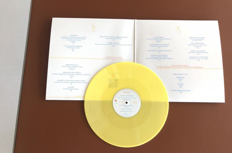 Il menu è impaginato in un doppio LP: aprendolo si trovano le proposte alla carta. Il vinile giallo vero e proprio (non riproducibile al giradischi, per ora) contiene i dettagli del menu degustazione
