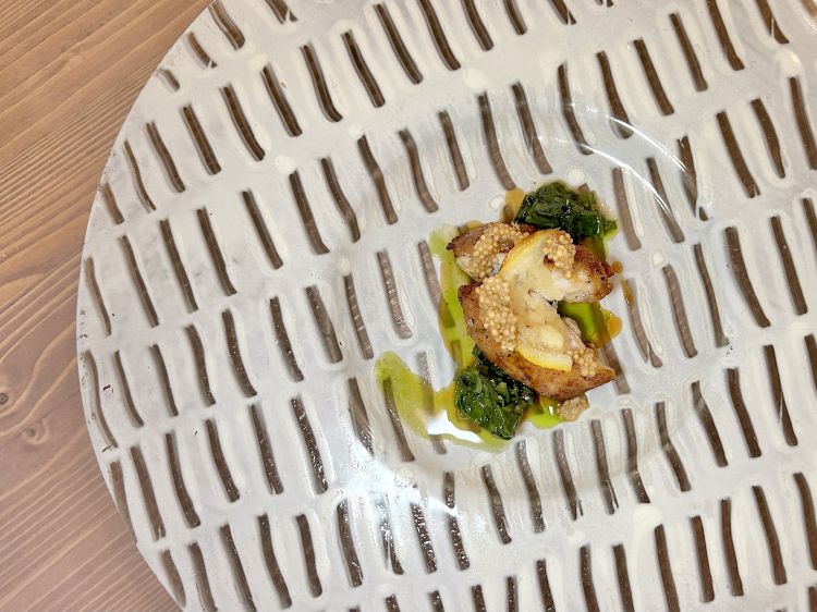 Animella arrosto, rucola, semi di senape e limone. Animella accompagnata da rucola cotta alla brace e poi marinata nel suo stesso estratto. Completano il piatto un limone arrostito e poi ghiacciato e una senape condita con estratto di senape. Il giusto assetto, con complessità aromatica molto coinvolgente e un morso perfetto