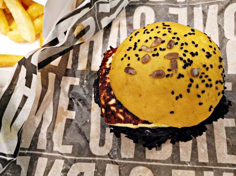 Hamburguesa vegetariana con formaggio cheddar e funghi, pane alla curcuma con semi di girasole e sesamo nero, prodotto da Sebastián Perez nel suo laboratorio artigianale El Arrobo, Panadería & Compañía
