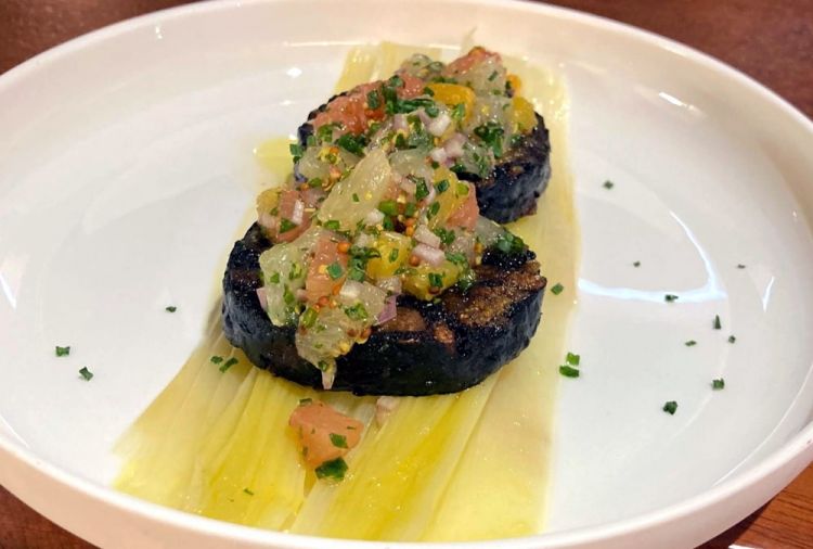 Porri alla brace con boudin noir (in Argentina: morcilla), immancabile in ogni asado che si rispetti. I porri sono cotti interi su fiamma viva. Vengono avvolti in un foglio di giornale, per pelarli più facilmente, se ne usa solo il cuore, molto morbido, aperti a metà e serviti con il boudin noir cotto alla brace nella padella di ghisa, in modo che risulti croccante all’esterno e morbido all’interno. La salsa criolla agrumata con cui viene servito è preparata con lima, limone, arance, pompelmi, mostarda in semi, scalogno, erba cipollina, olio e sale, ottima per equilibrare la componente grassa del boudin noir
