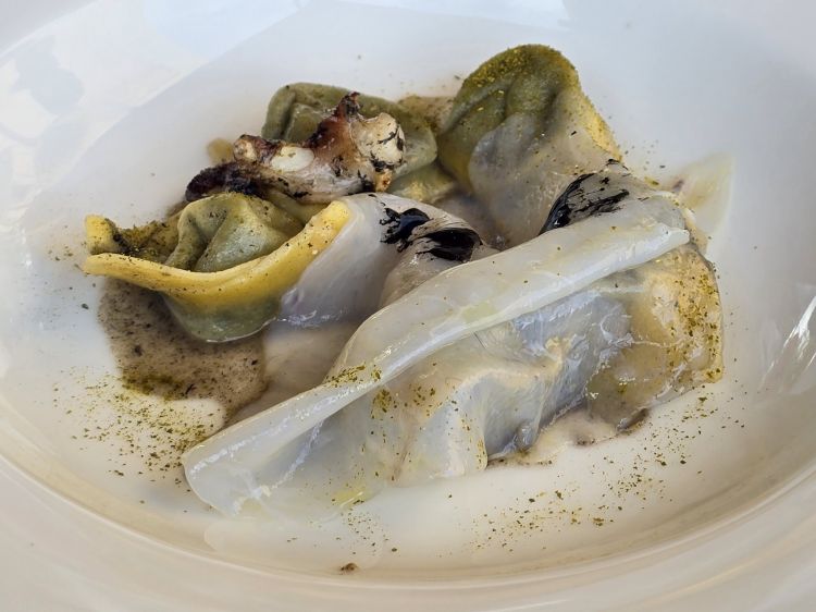 Tortello ripieno di seppia, velo di seppia, nero di seppia e brodo di seppia. Omaggio al mollusco in tutte le sue forme, è un piatto di grande intensità gustativa nonché è divertente incrocio di consistenze