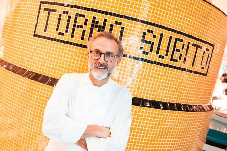 Massimo Bottura davanti all'iconica insegna de