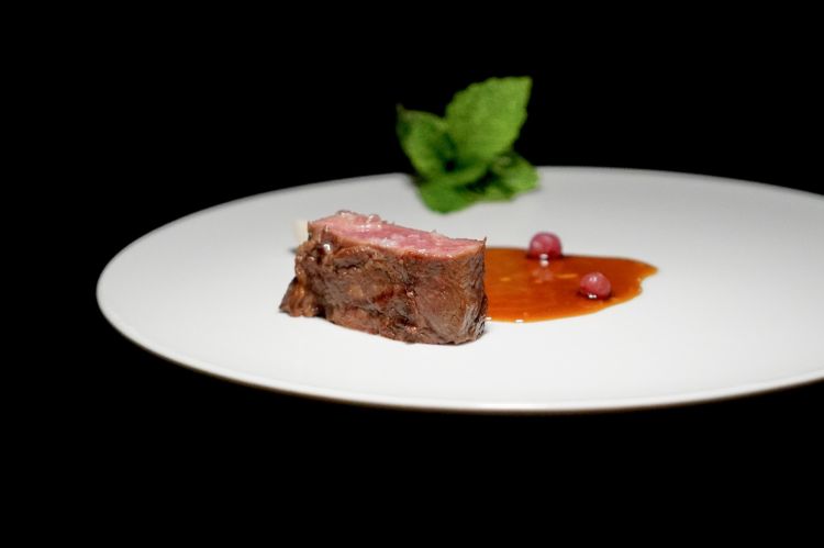 Magistrale Agnello al barbecue, rosmarino, ribes fermentato ed erbe. L&rsquo;agnello viene cotto interamente al barbecue e servito con un&rsquo;emulsione al rosmarino, ribes messi sotto sale e sottoposti a una lieve fermentazione, e il suo fondo di cottura emulsionato con il grasso della carne. Accanto compare un bouquet di erbe, sul quale in cucina convivono due interpretazioni. Secondo Antonio Biafora, le erbe dovrebbero accompagnare ciascun boccone di agnello; il sous Francesco Cardace suggerisce invece di conservarle fino alla fine e utilizzarle per raccogliere la salsa rimasta nel piatto. Entrambe le possibilit&agrave; funzionano: le erbe possono alleggerire e profumare la carne oppure diventare un ultimo boccone intensamente aromatico. Il piatto &egrave; armonico, perfetto. Le erbe fan tanto
