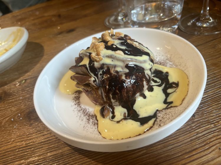 Un esageratisssimo maritozzo inzuppato in sciroppo di alchermes sormontato da namelaka rocher, salsa e fave di cacao e spuma fredda allo zabaione