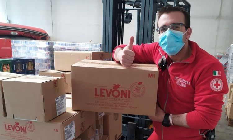 Un operatore della Croce Rossa di Bergamo mostra alcuni dei pacchi ricevuti da Levoni
