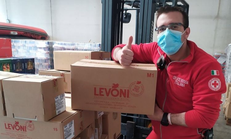 Un operatore della Croce Rossa di Bergamo mostra alcuni dei pacchi ricevuti da Levoni
