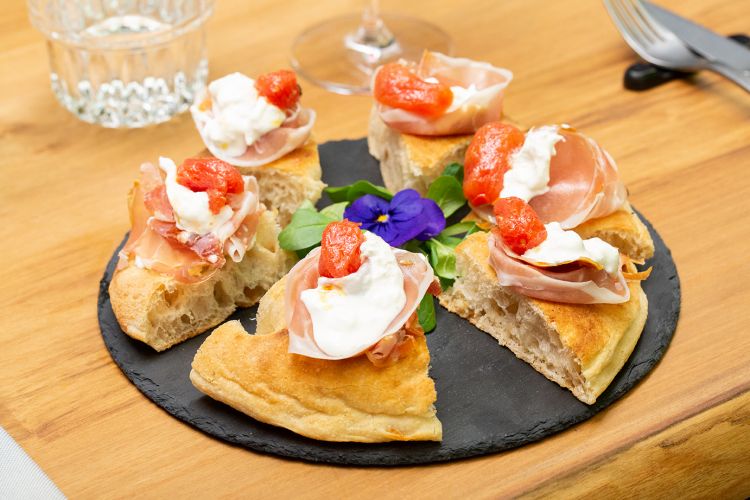 La focaccia, altro fiore all'occhiello di Nhero: una crosta dorata e fragrante all'esterno, dal cuore morbido farcito di ogni delizia del Bel Paese