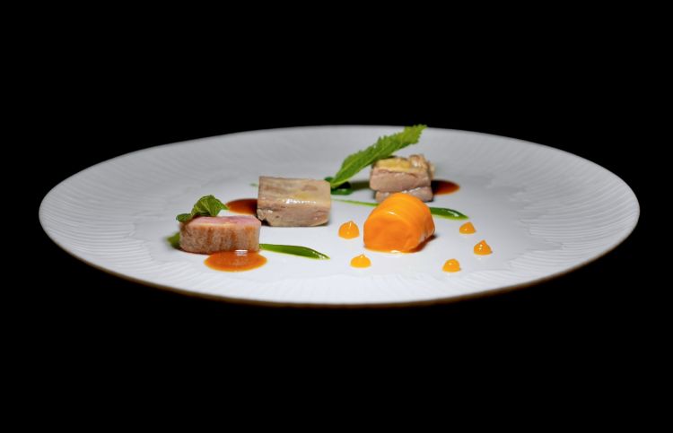 Agnello del Monte Baldo, olive candite, carota e ortiche: agnello da latte in tre tagli differenti (controfiletto, spalla e collo). Il controfiletto è lasciato rosa al cuore, la spalla e il collo vengono cotti confit. Con fondo di cottura, crema di oliva candita, quenelle di crema di ortiche con foglia di ortica fritta, carota ripiena di battuto di carote e nappata con glassa di carote