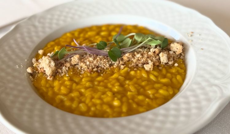Risotto Vialone Nano all'onda mantecato con crema di zucca mantovana, cipolla e salvia, servito con amaretti al rosmarino