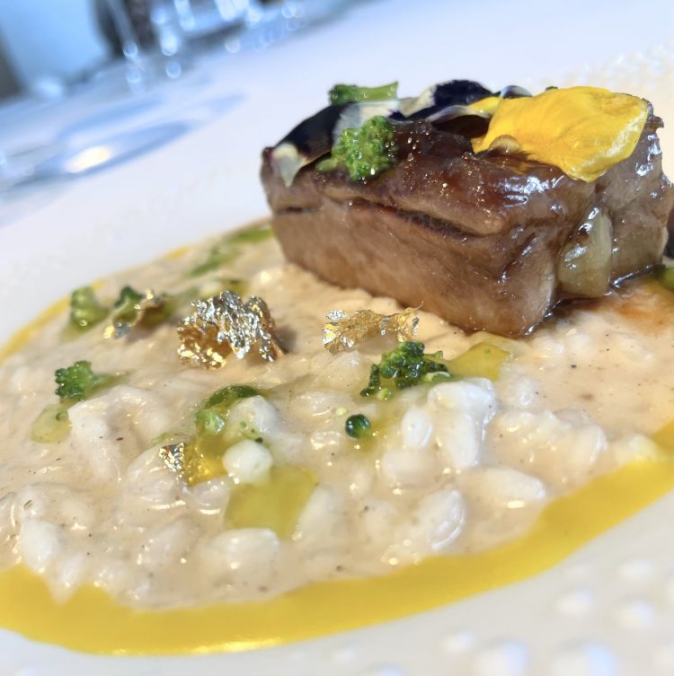 Risotto Franciacorta
Milano e Franciacorta si incontrano in questo risotto condito con salsa allo zafferano, bagnato al Franciacorta e servito con una costina di maiale nero arrostita; in conclusione, broccolo per spezzare la rotondità dell'assaggio con una venatura vegetale ben calibrata. Un piatto che unisce la raffinatezza del risotto a un tratto più rustico: quel delizioso pezzo di carne sfilacciosa e umida servita sullo stesso piatto