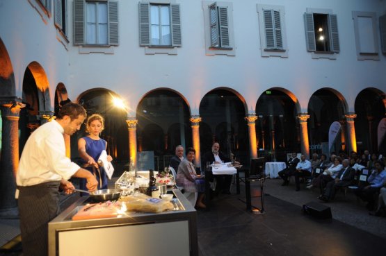 Alessandro Negrini, affincato sul palco da Elisa Pella durante la preparazione degli Spaghetti al cipollotto e peperoncino. Alessandro è chef con Fabio Pisani del Luogo di Aimo e Nadia, una nuova generazione capitanata da Stefania Moroni