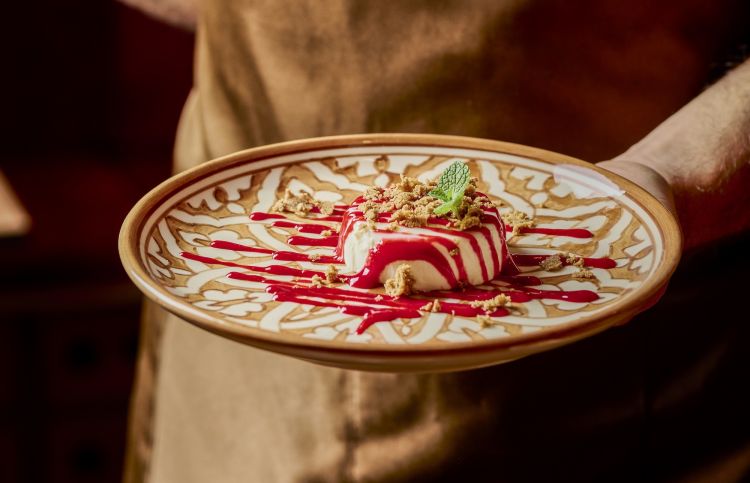 Panna cotta Amina, un classicissimo della cucina italiana che Monir ha reinterpretato in chiave marocchina, con acqua di rose, cardamomo, terra di sellou e coulis di lamponi
