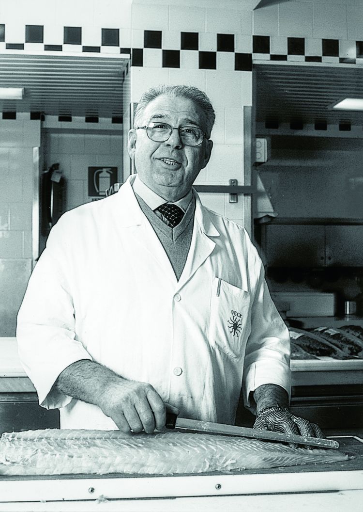 Un Angelo Stoppani, già coi capelli bianchi, alle prese col taglio del salmone