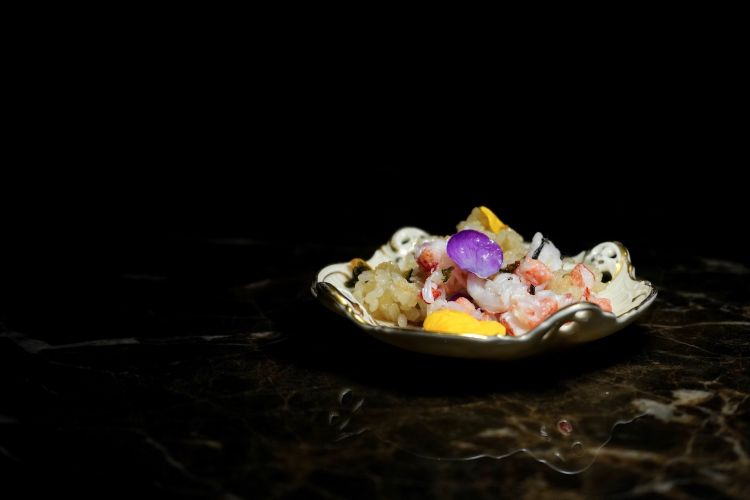 To accompany, sticky rice, but not in the dessert version: rice cooked in dashi, stir-fried, then seasoned with lobster tails, Pantelleria capers and edible flowers
