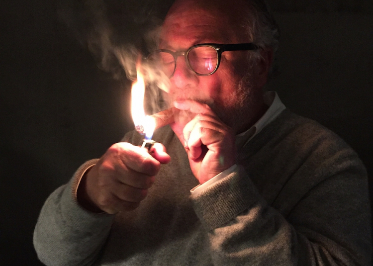 A portrait of Antonello Colonna lighting a Cohiba
