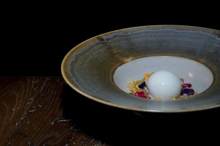 Nocciola e caffè: cremoso alla nocciola e caffé ricoperto di ganache al cioccolato bianco. Ai lati, crumble di savioardi alla nocciola e kombucha al caffè. Poi i fiori, che non sono solo decorativi, ma forniscono variazioni aromatiche interessanti