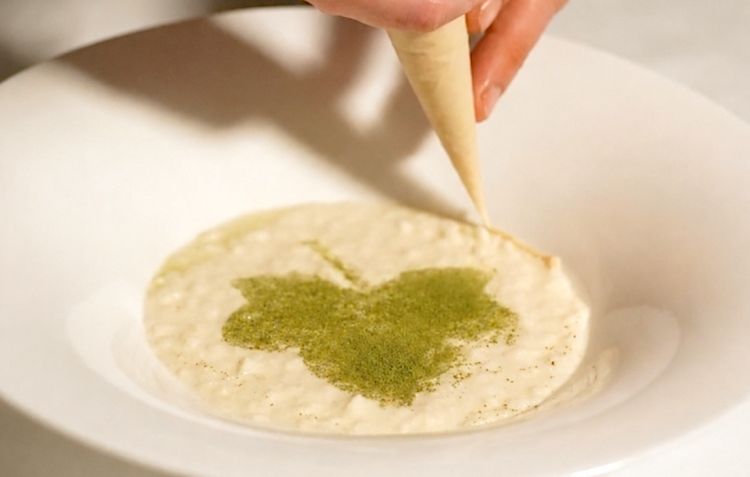 Risotto Vialone nano&nbsp;mantecato con crescenza e Parmigiano Reggiano, con variazione di foglie di fico e mandorle
