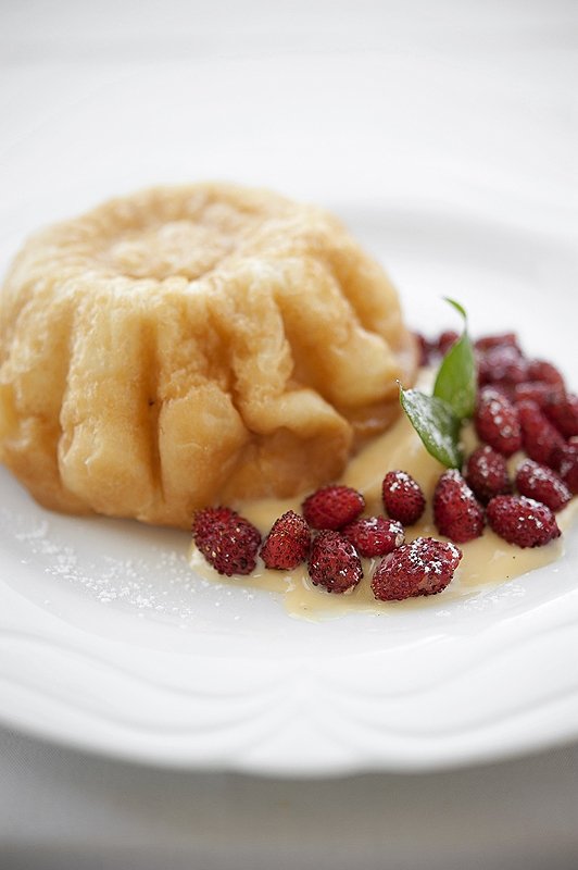 Babà napoletano, servito con crema pasticciera e fragoline di bosco