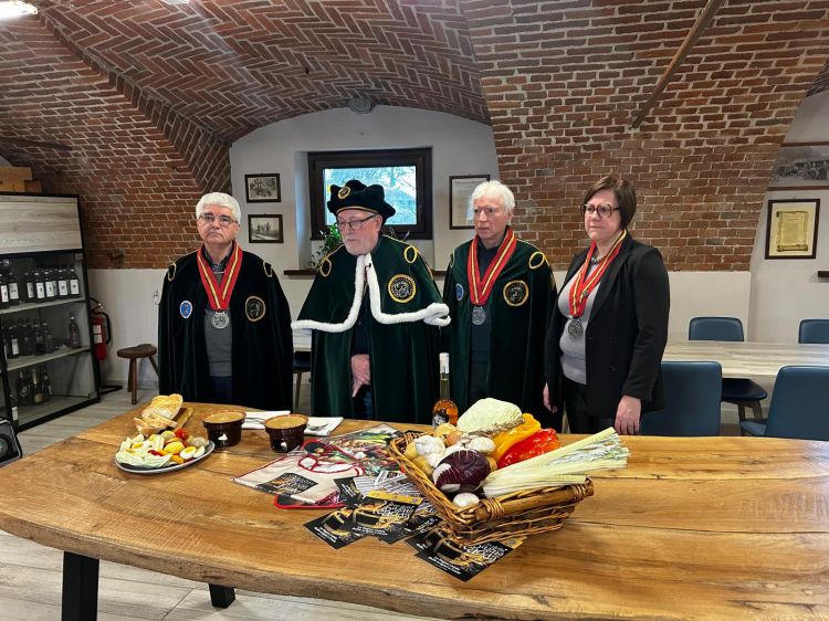 I rappresentanti dell'Accademia della bagna caöda di Faule. Le origini di questa specialità sono comuni a quelle della sua "sorella maggiore", la bagna càoda "classica", tipica di numerose zone del Piemonte, e affondano nel lontano Medioevo. Non è possibile individuare una data precisa per la nascita di questo piatto; sebbene essa sia presente da secoli sulle tavole piemontesi, fino all'inizio del XX secolo non era tuttavia inserita in ricettari o trattati di gastronomia. Già alla fine del 1300 il medico Antonio Guainerio, pavese di origine ma piemontese di adozione (fu attivo tra Torino e Chieri), nel trattato dal titolo Opus praeclarum ad praxim non mediocriter necessarium afferma che "l'aglio è la salsa dei contadini, i quali a volte lo cuociono con mollica di pane, cosa che per i francesi e gli ultramontani non ha niente di superiore". Non è di certo ancora la bagna càoda (non è confermata la presenza delle acciughe), ma questo sapor rusticum, come definito dal Guainerio, può a ragione essere considerato un suo antenato. Quasi quattro secoli dopo, nel libro di autore ignoto Il cuoco piemontese perfezionato a Parigi, del 1766, viene invece presentata la salsa del pover'uomo, discendente diretta del sapor rusticum medioevale, alleggerita nei dosaggi ma molto simile nella preparazione, che prevede esplicitamente anche l'utilizzo delle acciughe: "Mettete in una casseruola un po' di butirro, un po' d'olio, un'acciuga e un baccello d'aglio triturato; fate cuocere, indi aggiungetevi del pane grattugiato con brodo, e ridotta la salsa consistente, la verserete sull'intingolo che servirete caldo". La diffusione della bagna càoda (o bagna caöda) in Piemonte è probabilmente collegata alle attività commerciali che legavano storicamente il territorio piemontese e quello ligure e d'oltralpe. L'antica e costante frequentazione delle saline provenzali mise in contatto i mercanti di acciughe, in particolare quelli della Val Maira, con un curioso cibo tipico dei pescatori e degli operai del sale provenzali: l'anchouiado. Esso consisteva in una salsa di acciughe, olio e aglio, mantenuta calda, in cui i commensali, a turno, intingevano il pane, che poi veniva fatto ulteriormente gratinare sul fuoco; in sostanza una salsa calda che i carovanieri del sale, assieme a questo e alle acciughe, hanno portato in patria. Salsa che per i contadini divenne inizialmente il sapor rusticum e, in seguito, la bagna càoda, arrivata più tardi anche sulle tavole borghesi, e in alcuni casi della nobiltà, come intingolo rustico ma appetitoso