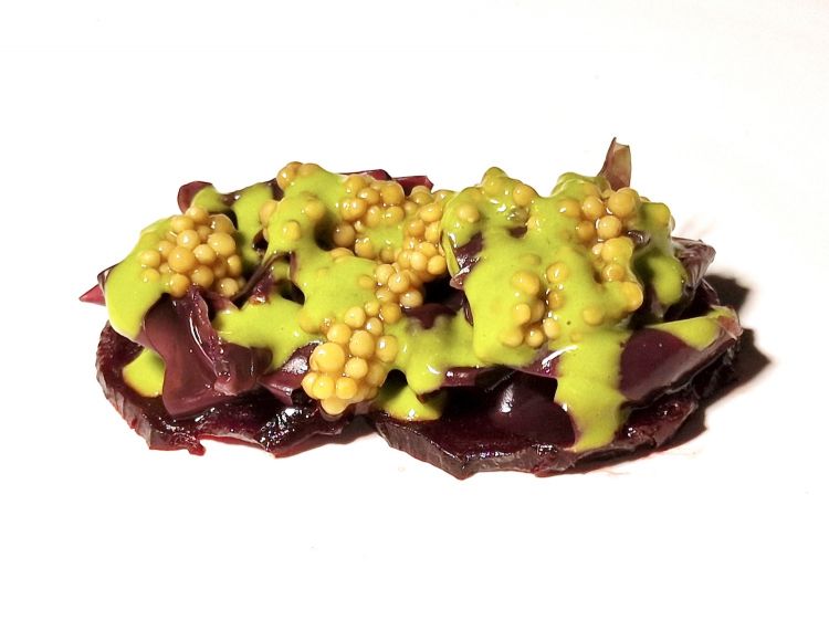 Barbabietola cotta tra i carboni con alga dulse, lattuga di mare e rucola in crema verde e semi di senape
