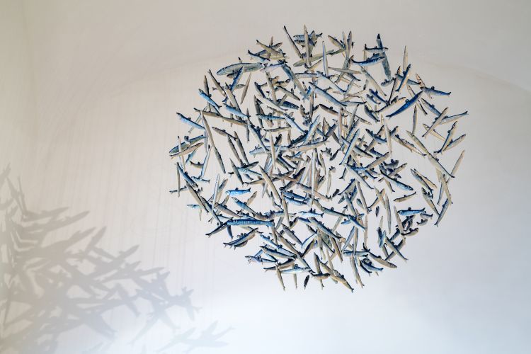 La Palla di Alici, scultura sospesa in ceramica realizzata dall’artista vietrese Lucio Liguori per il Borgo Santandrea di Amalfi, dove si trova il ristorante Alici. L’opera è composta da numerose alici in ceramica disposte a formare una sfera, concepita per sembrare sospesa nell’aria e per evocare un banco di pesci che nuota e si muove all’unisono. È quindi soprattutto un’opera simbolica: richiama il mare della Costiera Amalfitana, la tradizione della pesca del pesce azzurro e il legame con Cetara. Liguori lavora da decenni sulla ceramica vietrese e negli ultimi anni l’alice è diventata uno dei suoi soggetti distintivi, quasi una firma
