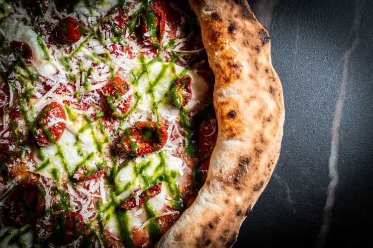 La Bufala extra, con bufala campana, pomodoro, emulsione al basilico, parmigiano 50 mesi e datterino confit