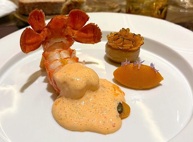 Buisson divin:&nbsp;consomm&eacute; di scampi, burro di chele tostate, salsa di corallo, essenza di zucca, marinata floreale, aceto di fiori, riduzione di scalogno, macerazione di agrumi con vino Chardonnay
