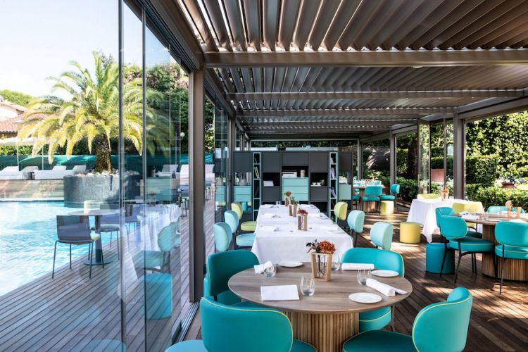 I tavoli all'aperto, accanto alla piscina, della Magnolia, il ristorante dell'hotel Byron, 5 stelle lusso a Forte dei Marmi in Versilia

