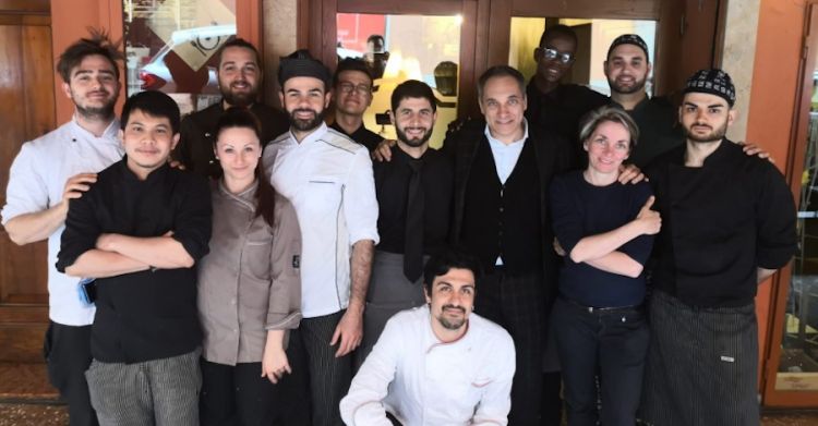 Foto ricordo tutti assieme per la sala e la cucina dei due locali curati da Paolo Carati, quasi al centro con un cardigan nero, collo a V e camicia bianca
