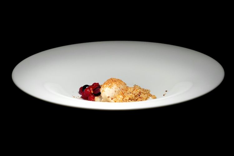 Scorzonera, cioccolato caramellato, gelato di pane e lieviti, crumble di farine integrali e conserva di mirtilli sotto gin. La scorzonera perde la sua parte amara cuocendola lentamente, sulla stufa, col latte, «diventa come una crema pasticcera»