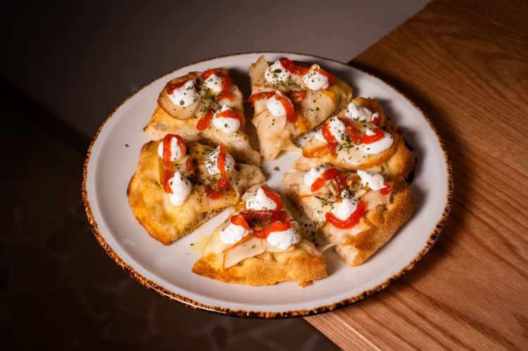 Ricotta e pera; pizza alla pala con fiordilatte, in uscita ricotta di capra, confettura di peperoncino, foglie di fico essiccate e sbriciolate e scaglie di cioccolato fondente