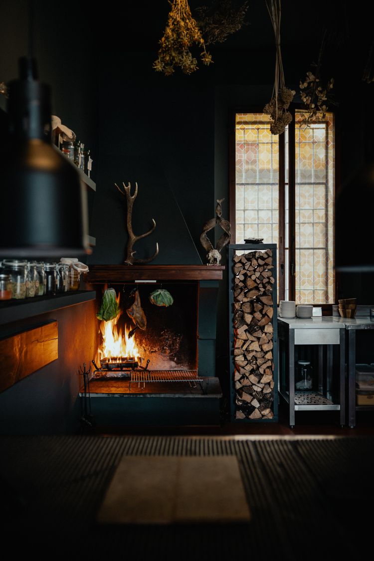 L'atmosfera a Casa Serafini racconta il bosco: camino acceso, mazzi di fiori secchi e cestini di paglia appesi al soffitto
