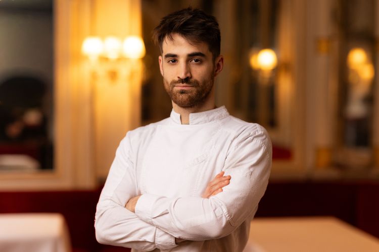 Francesco Rovai &egrave; un giovane chef toscano, classe 1999, originario di Pistoia, cresciuto in una famiglia gi&agrave; legata alla ristorazione. Dopo l&rsquo;alberghiero ha costruito un percorso molto internazionale: Bruxelles all&rsquo;Hotel Amigo, poi due anni a Londra da Le Gavroche dei fratelli Roux, quindi il rientro in Italia da Davide Di Fabio al Dalla Gioconda. Nel 2024 &egrave; approdato al ristorante Del Cambio di Torino, dove alla fine del 2025 &egrave; diventato chef. Il suo lavoro qui &egrave; particolarmente interessante perch&eacute; ruota attorno alla ricerca storica sulla cucina piemontese e sul suo dialogo con la tradizione francese: vecchi ricettari, tecniche classiche, piatti sabaudi riletti con sensibilit&agrave; contemporanea. &Egrave; lui oggi a guidare la visione gastronomica e la ricerca storica del ristorante, in una cucina che prova a trasformare la memoria in linguaggio attuale
