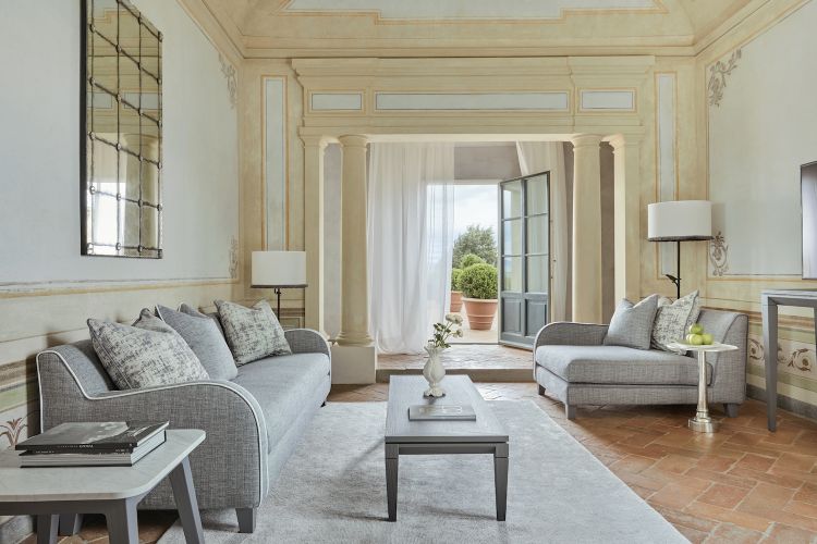 L'area living di una delle eleganti camere e suite di COMO Castello del Nero, nel cuore del Chianti.
