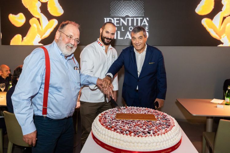 Claudio Ceroni e Paolo Marchi tagliano la torta di compleanno dell'Hub insieme a Davide Comaschi, pastry chef del gruppo Da Vittorio, che l'ha realizzata
